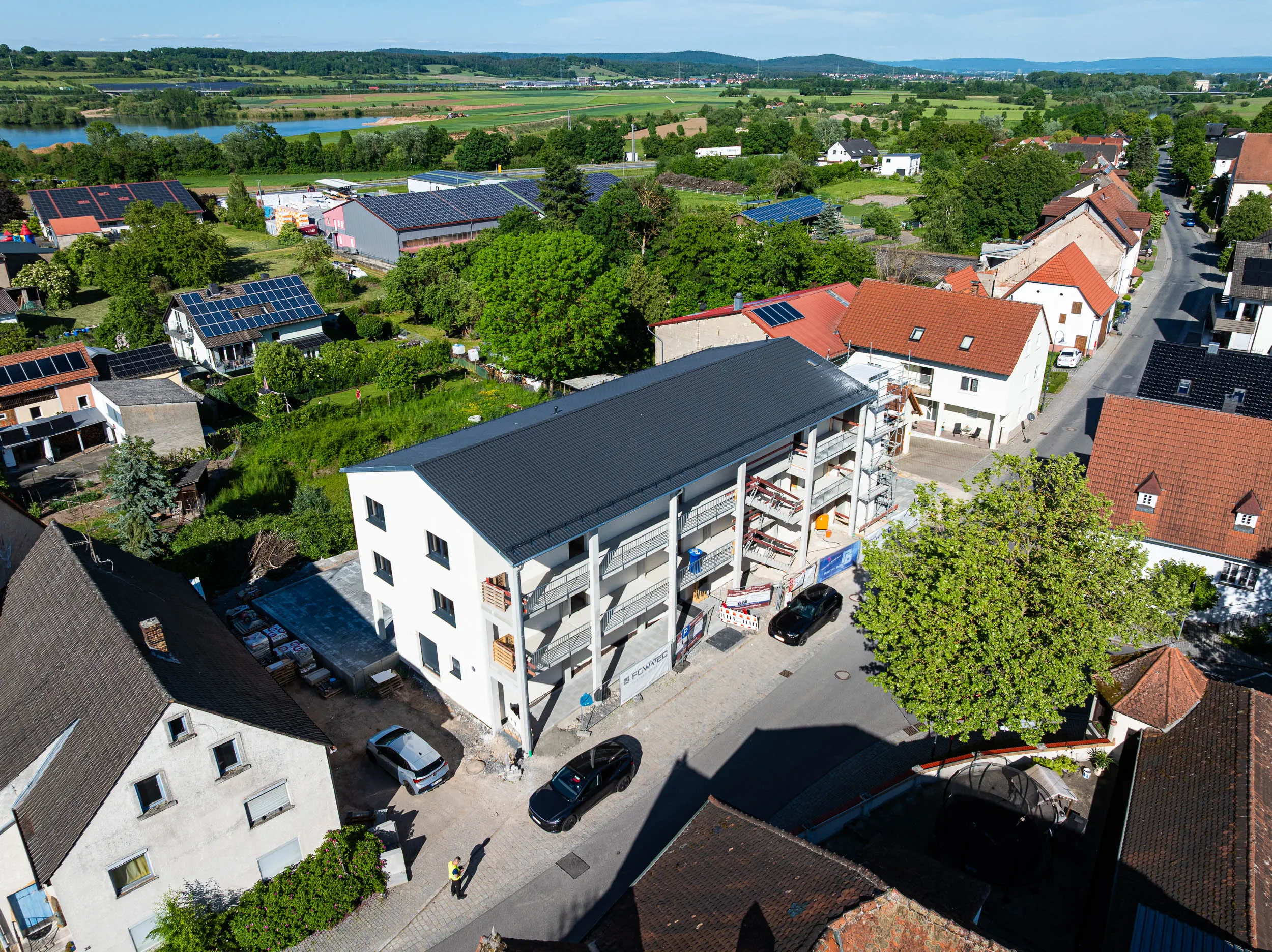 Neubau Trunstadt von oben — Dach und Balkone mit Main und Mainauen im Hintergrund